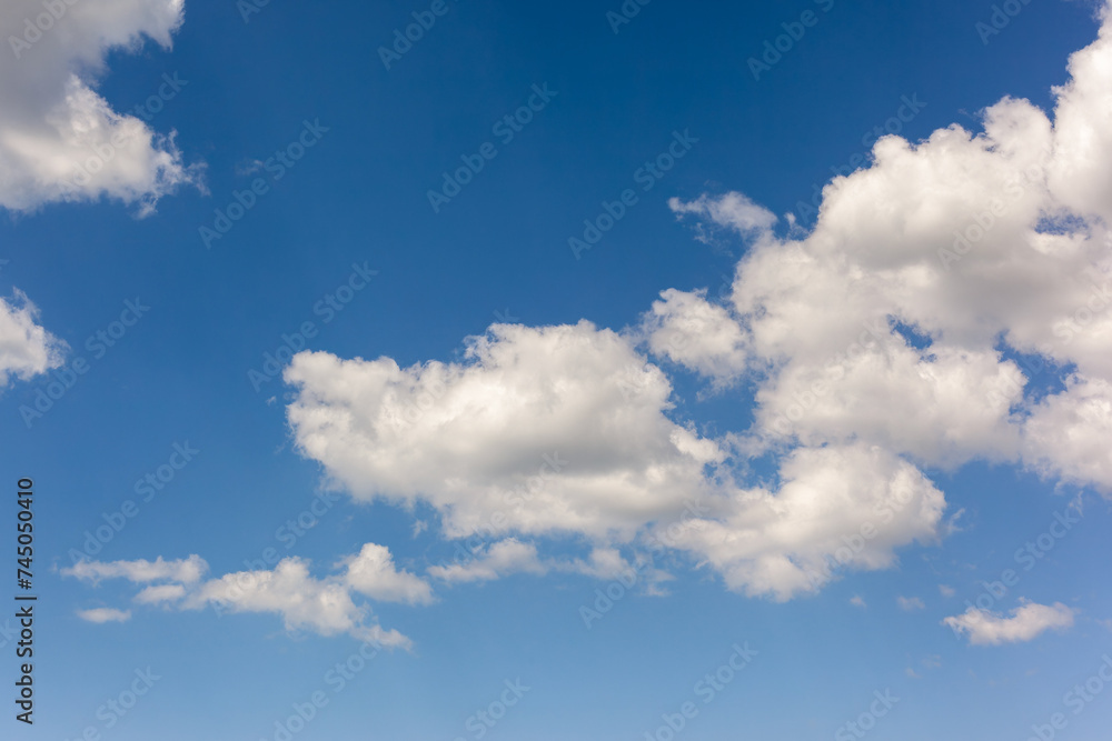 Fototapeta premium Beautiful background image of a romantic blue sky with soft fluffy white clouds