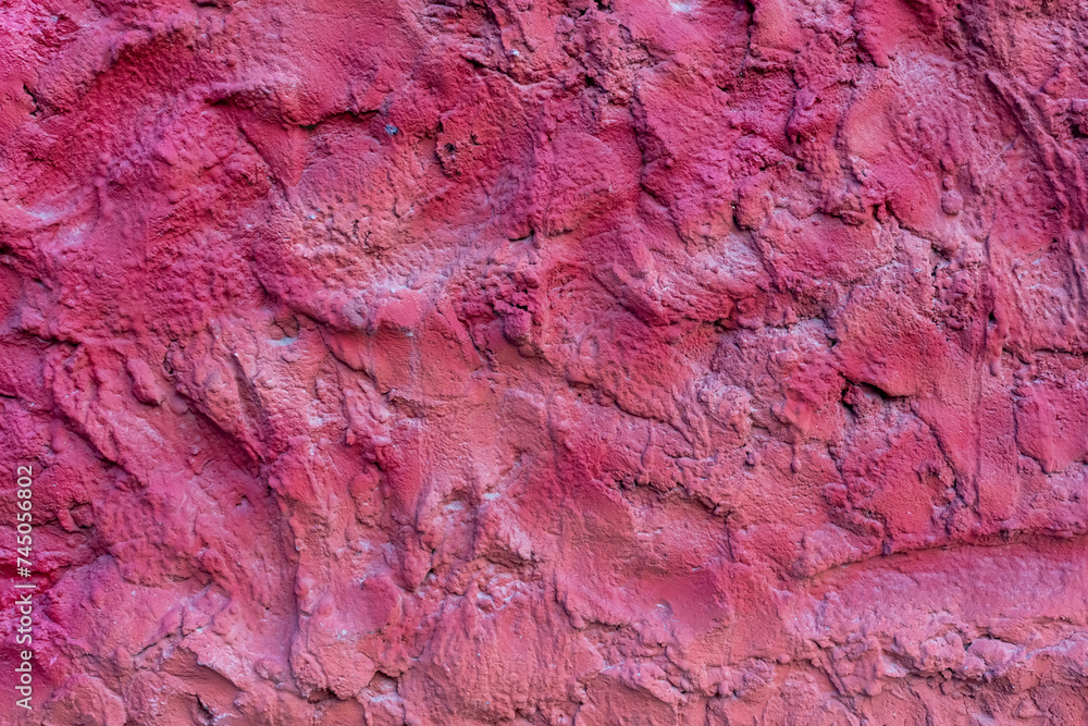 Close-up view of old textured magenta coloured rough plaster wall surface. Copy space for your text or decoration. Soft focus. Colorful construction material background theme. Close-up view of old textured magenta coloured rough plaster wall surface. Copy space for your text or decoration. Soft focus. Colorful construction material background theme.