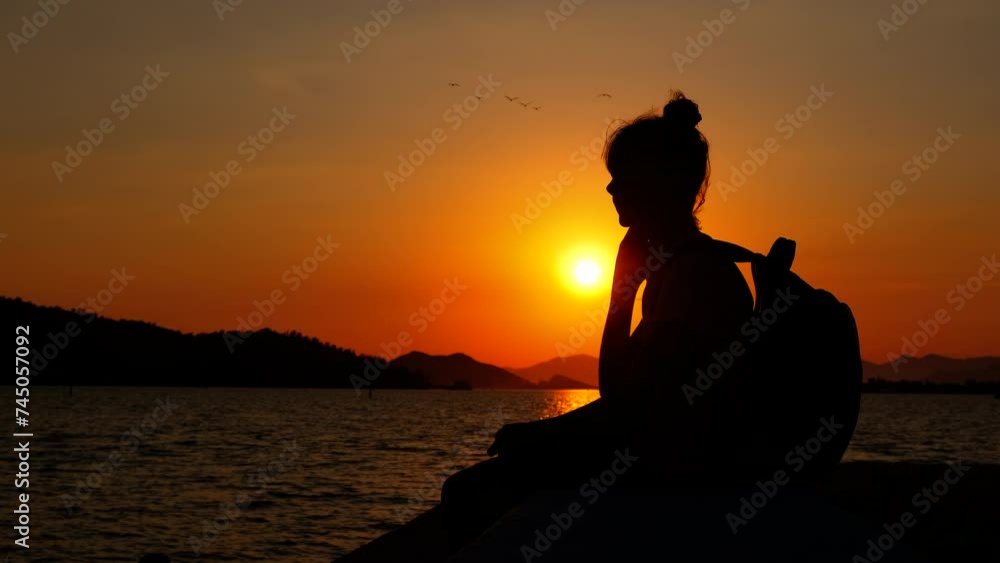 Silhouette of a young girl traveler enjoying the sea sunset Silhouette of a young girl traveler enjoying the sea sunset