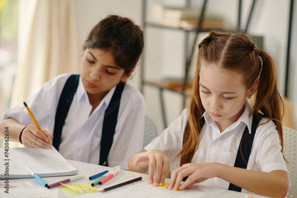 Schoolgirls working on school project in class Schoolgirls working on school project in class