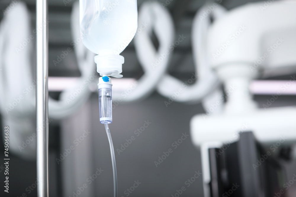 A dropper for intravenous infusion of saline solution or medications. Hospital room or surgery. Emergency care for the patient and assistance in the infusion of injectable drugs. Selective focus. A dropper for intravenous infusion of saline solution or medications. Hospital room or surgery. Emergency care for the patient and assistance in the infusion of injectable drugs. Selective focus.