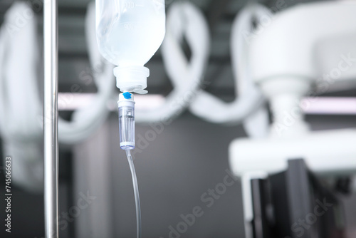 A dropper for intravenous infusion of saline solution or medications. Hospital room or surgery. Emergency care for the patient and assistance in the infusion of injectable drugs. Selective focus. photo