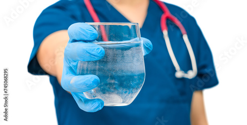 Lekarz wyciąga dłoń w której trzyma szklankę pelną wody mineralnej, promowanie picia wody