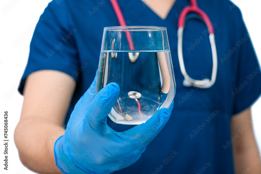 Lekarz trzyma w dłoni szklankę pełną wody, nawodnienie organizmu - obrazy, fototapety, plakaty 
