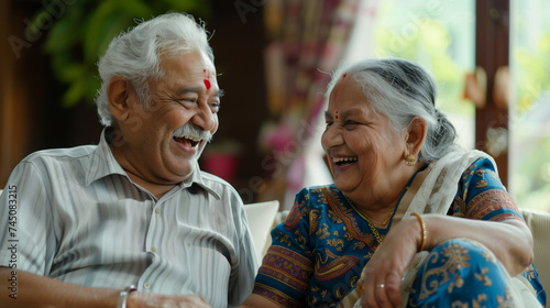 Two elderly Indian people talking and laughing together.