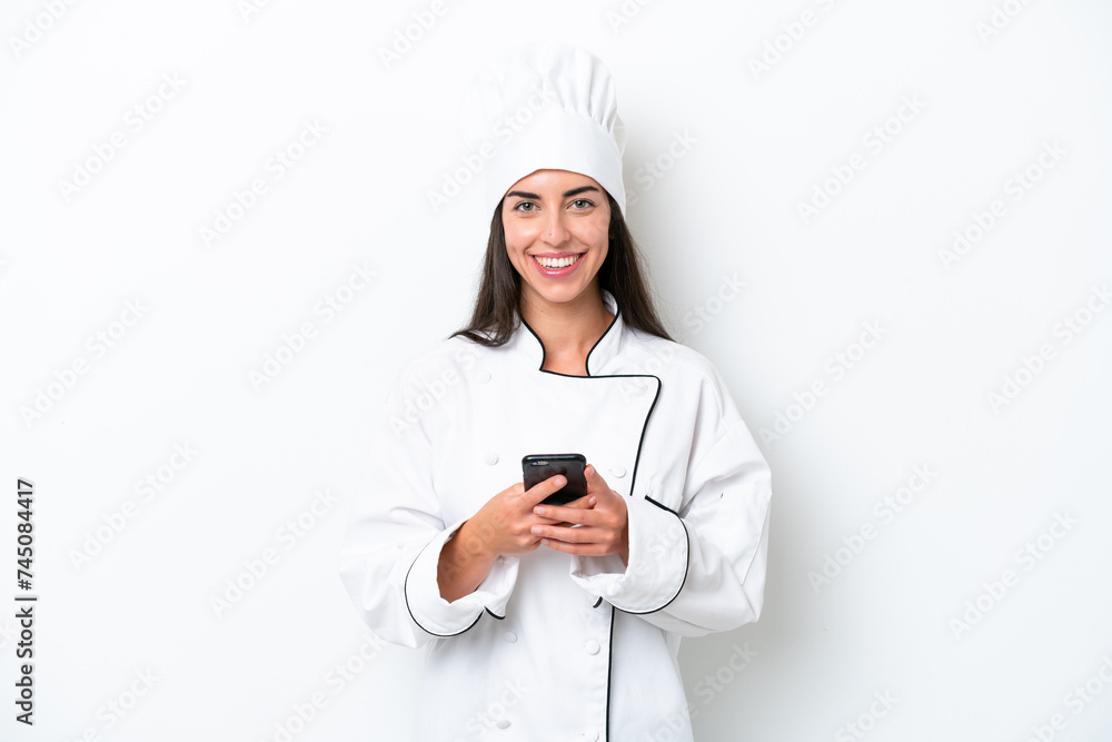 Young chef woman over white background sending a message with the mobile Young chef woman over white background sending a message with the mobile