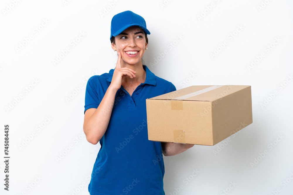 Delivery caucasian woman isolated on white background thinking an idea while looking up