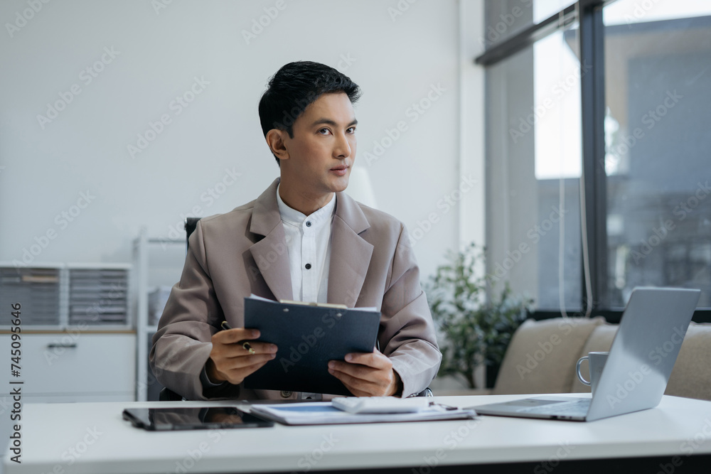 Business man working at office with laptop and documents on his desk, financial adviser analyzing data. Business man working at office with laptop and documents on his desk, financial adviser analyzing data.