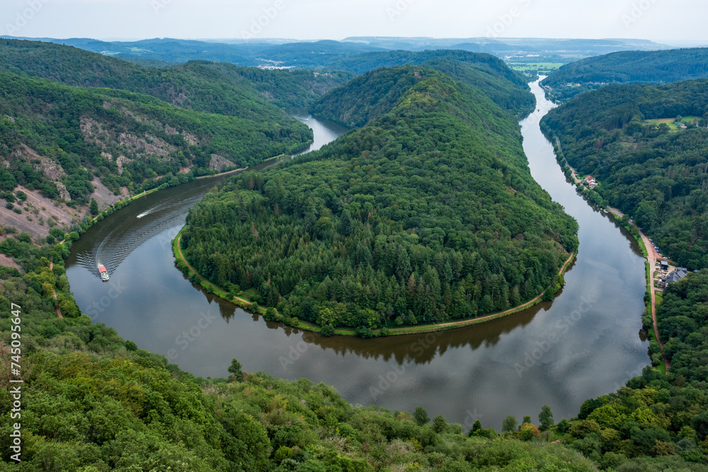 Majestic view of Saar River flowing through the famous Saarschleife in western Germany, surrounded by lush green forest