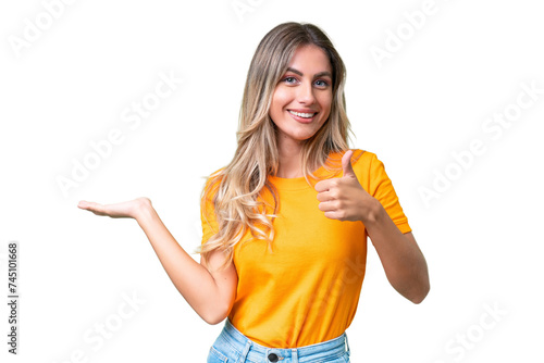 Fotografie Young Uruguayan woman over isolated background holding copyspace imaginary on th