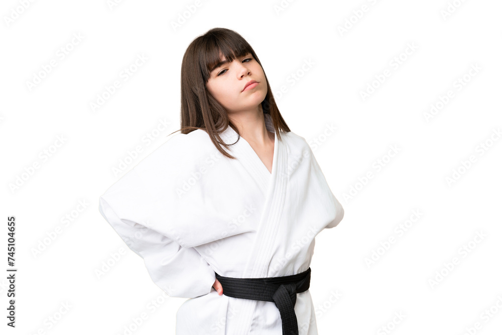 Little Caucasian girl doing karate over isolated background suffering from backache for having made an effort Little Caucasian girl doing karate over isolated background suffering from backache for having made an effort