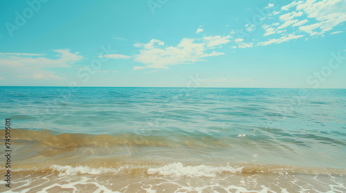 Serene Beachside Horizon under Clear Blue Skies, Calm turquoise sea meets a clear sky, gentle waves lapping sandy shore