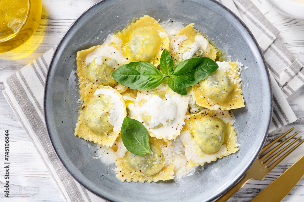 Homemade Ravioli pasta with spinach and ricotta cheese filling with creamy white sauce and grated Parmesan cheese. top view Homemade Ravioli pasta with spinach and ricotta cheese filling with creamy white sauce and grated Parmesan cheese. top view