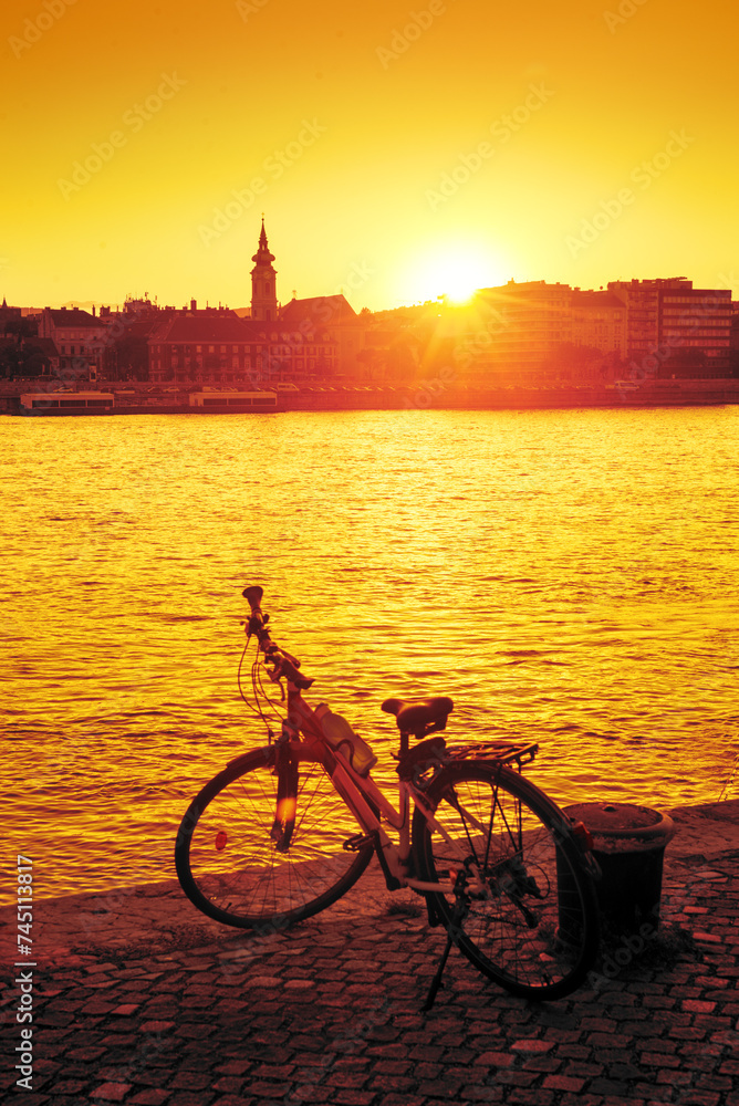 Bicycle against sunset on the river