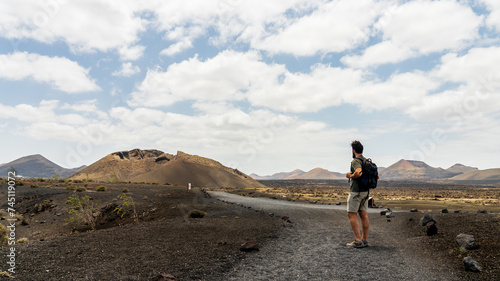 Adventurous man walking towards a volcano crater
