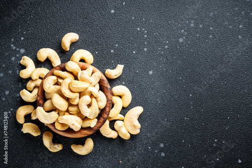 Cashew nuts in bowl at black background.