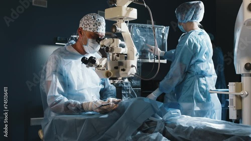A doctor uses a microscope during eye surgery or diagnosis, cataract treatment and diopter correction. A surgeon looks through a microscope at a patient's eyes in the operating room. photo