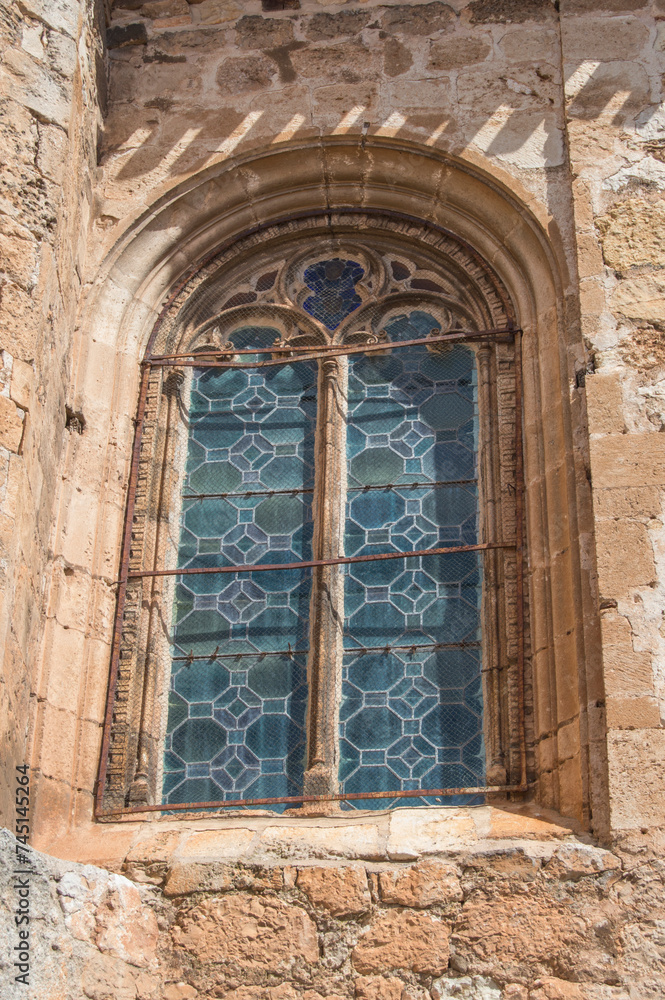 exterior of gothic window with stained glass on a stone facade