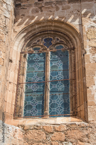 exterior of gothic window with stained glass on a stone facade