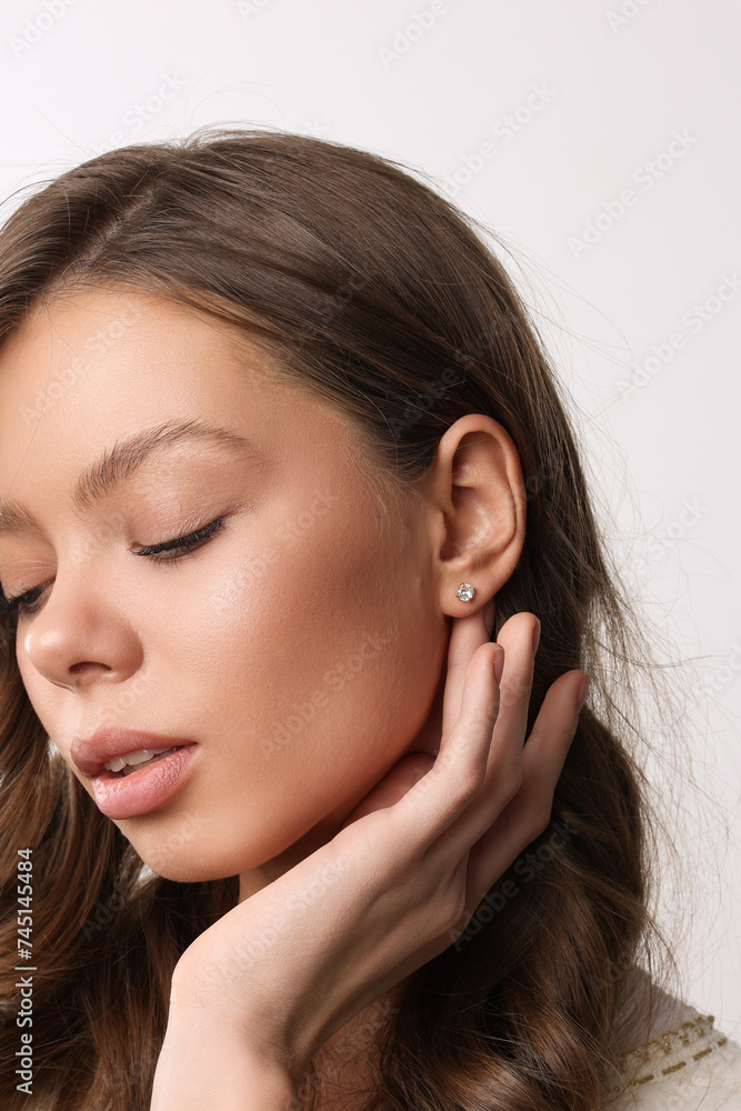 Beautiful young girl with fresh healthy skin. Woman advertise ear-rings. White background. Earrings closeup. Blond european woman with long hair with big lips, pretty smile. Cosmetology, scincare. Beautiful young girl with fresh healthy skin. Woman advertise ear-rings. White background. Earrings closeup. Blond european woman with long hair with big lips, pretty smile. Cosmetology, scincare.