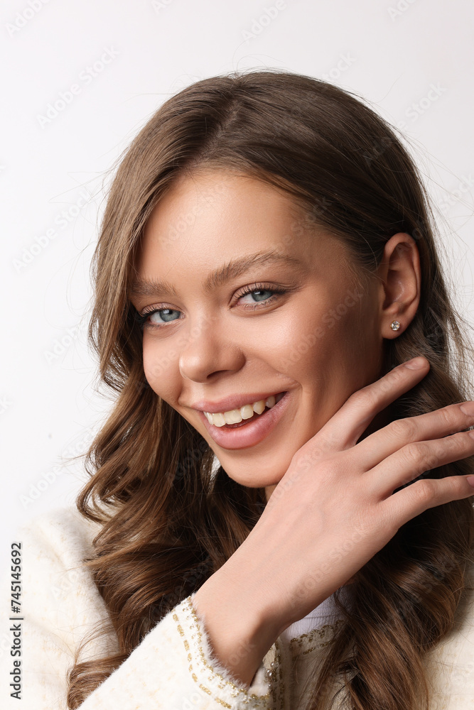 Beautiful young girl with fresh healthy skin. Woman advertise ear-rings. White background. Earrings closeup. Blond european woman with long hair with big lips, pretty smile. Cosmetology, scincare. 