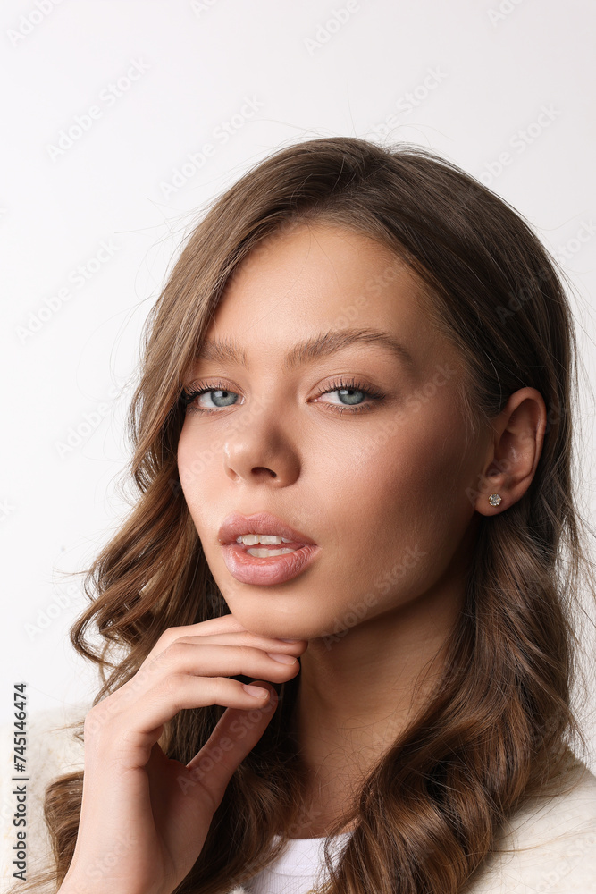 Beautiful young girl with fresh healthy skin. Woman advertise ear-rings. White background. Earrings closeup. Blond european woman with long hair with big lips, pretty smile. Cosmetology, scincare. 
