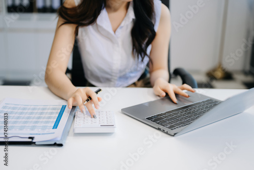 Woman freelancer is working her job on computer tablet and laptop Doing accounting analysis report real estate investment data, Financial