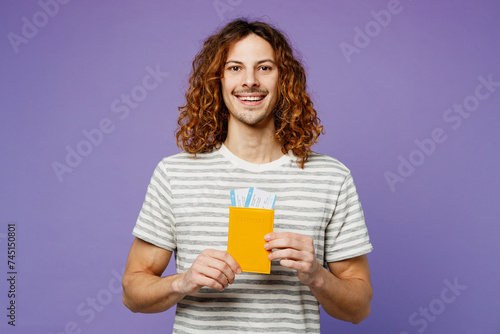 Traveler happy man wear casual clothes hold boarding passport ticket isolated on plain pastel purple background. Tourist travel abroad in free spare time rest getaway. Air flight trip journey concept.