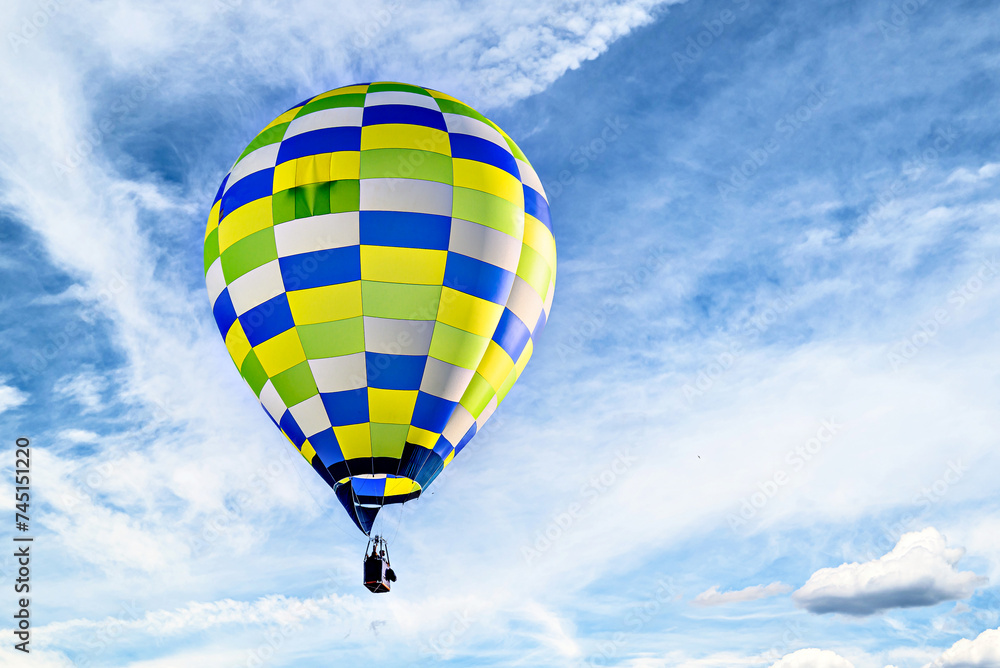 Fototapeta premium Colorful hot air balloon flying over blue sky with white clouds 