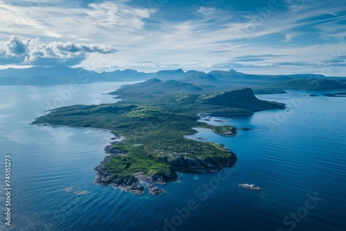 A breathtaking aerial view of a lush green island surrounded by the serene blue ocean.