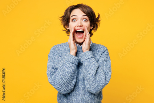 Tableau sur toile Young woman wears grey knitted sweater shirt casual clothes scream sharing hot news about sales discount with hands near mouth isolated on plain yellow background studio portrait