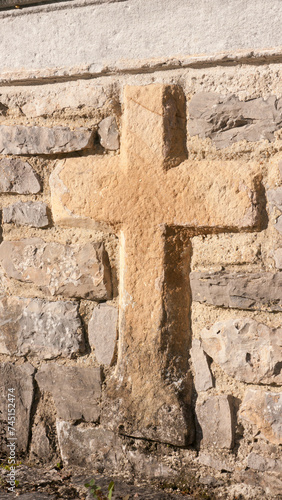 Cruz de piedra en muro