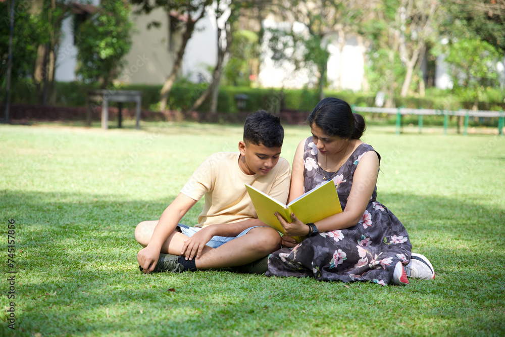 Happy mother and her teenage son spending time together with book Happy mother and her teenage son spending time together with book