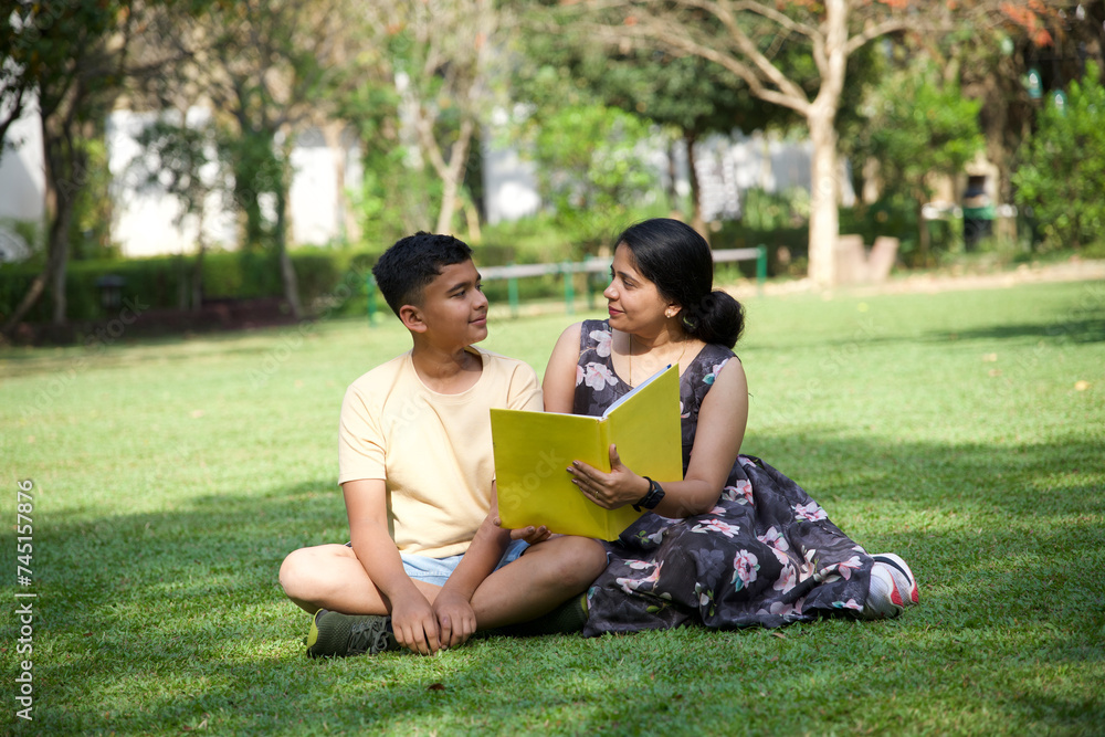 Happy mother and her teenage son spending time together with book Happy mother and her teenage son spending time together with book