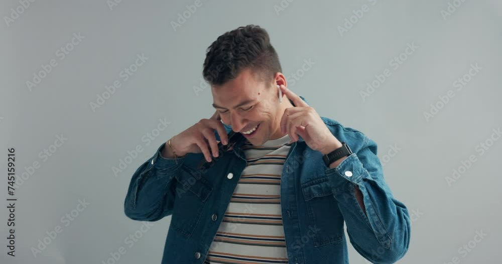 Man, dancing with earpods and smartphone for music, fun and energy in studio with happiness on grey background. Mobile app for entertainment, technology for moving with rhythm and listening to radio Man, dancing with earpods and smartphone for music, fun and energy in studio with happiness on grey background. Mobile app for entertainment, technology for moving with rhythm and listening to radio