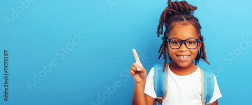 Happy African American girl with backpack showing thumbs up. Light background, horizontal frame, copy space frame. School learning concept, back to school