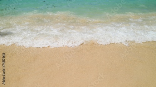 Footage of small waves splashing on the sand beach with pebbles, nature background