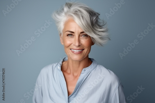 Beautiful gorgeous 60s mid aged mature woman looking at camera isolated on white. Mature old lady close up portrait. Healthy face skin care beauty, middle age skincare cosmetics, cosmetology concept © Darya