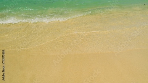 Footage of small waves splashing on the sand beach with pebbles  nature background