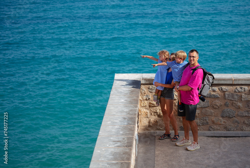 Happy tourists at Peniscola castle, admiring turquoise sea