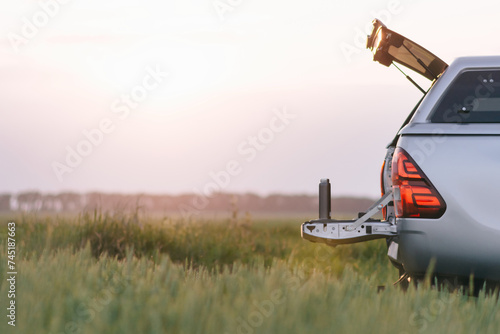 A back view of a car with a trailer attached, ready for transportation.