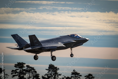 F35 coming into land at RAF Lakenheath with landing gear down during sunset, image shows a colourful sunset with clouds photo