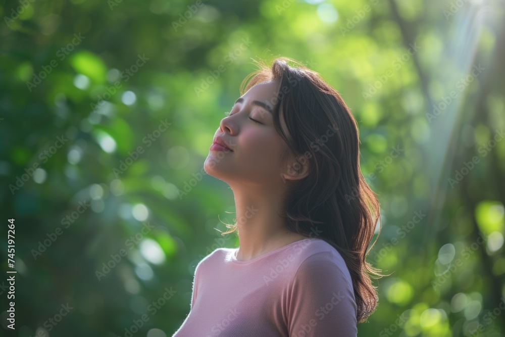 A woman stands peacefully amidst a serene forest, her eyes closed in a moment of mindfulness and connection with nature A woman stands peacefully amidst a serene forest, her eyes closed in a moment of mindfulness and connection with nature