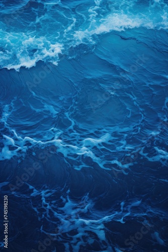 A stunning image of a blue ocean with waves and foamy water. Perfect for travel and nature themed designs
