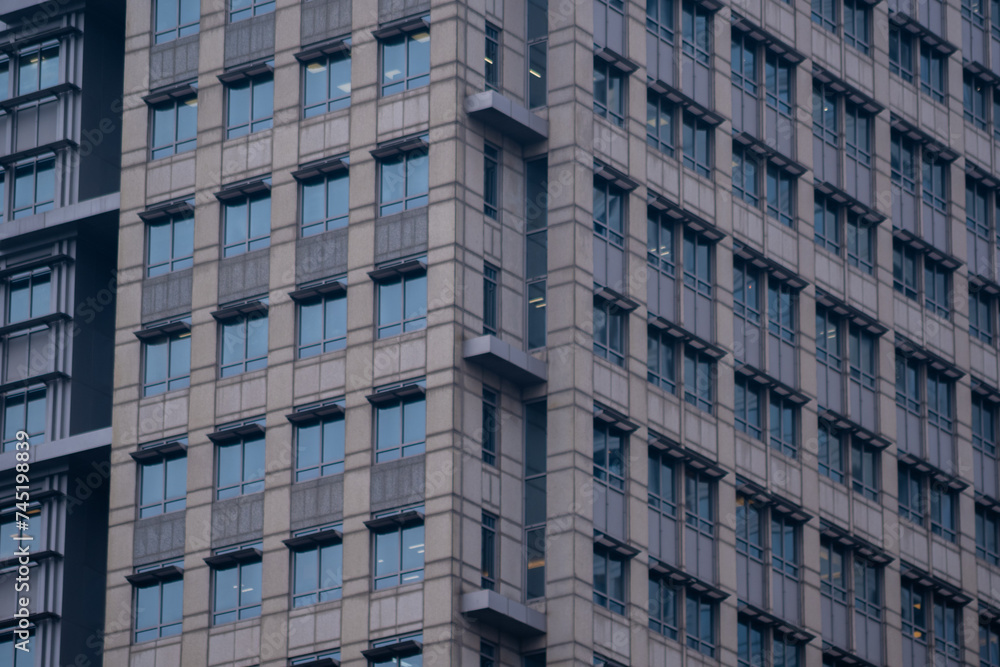 Exterior of modern skyscraper object. Architectural detail of a skyscraper, close-up on the windows. Real estate, residential apartments and offices. Office building architecture.