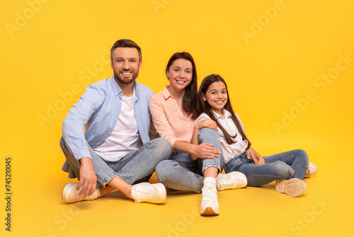 Happy family of three sharing moment of togetherness sitting, studio