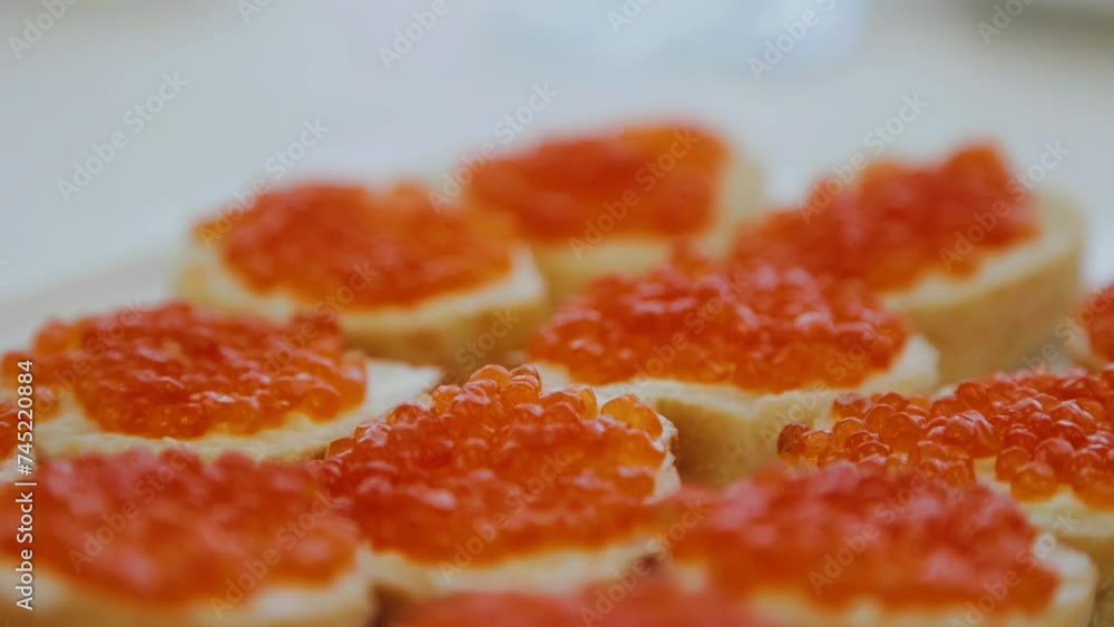 Delicious sandwiches with red caviar are on a plate on the festive table. Close-up food photography Delicious sandwiches with red caviar are on a plate on the festive table. Close-up food photography