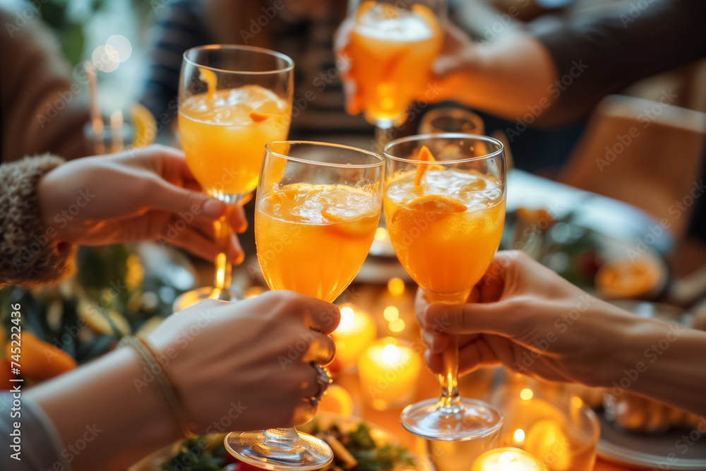 Hands toasting mocktails over the table at cozy gathering