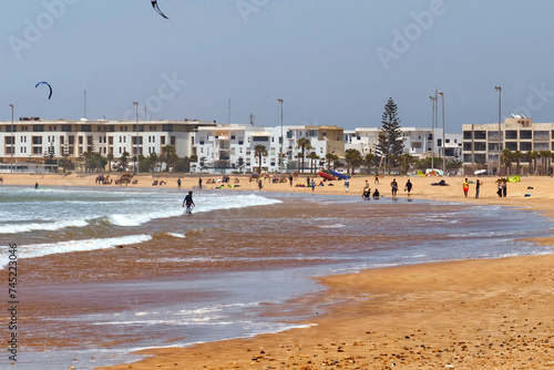 Sand beach with the resting people on the Atlantic coast. Essaouira, Morocco.