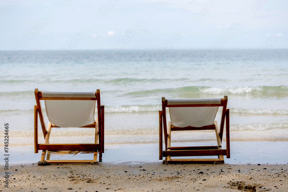 Two chairs on the beach.  Chairs on the sandy beach near the sea. Summer holiday and vacation concept for tourism.